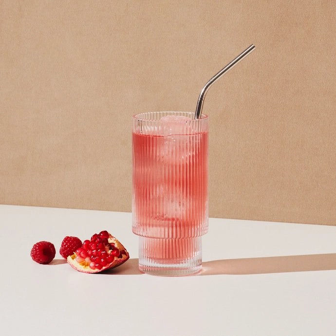 A glass of hydrating electrolyte drink mix in berry and pomegranate flavour from Cure Hydration.