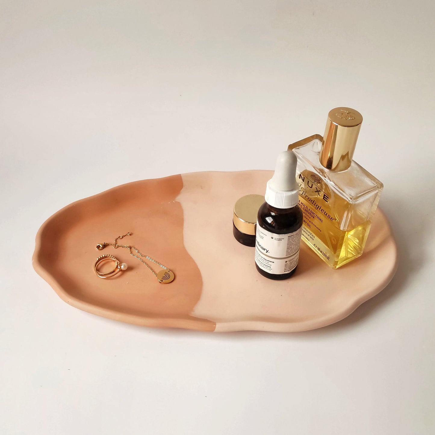 Handmade jesmonite vanity tray in neutral colors by Kndly home, organizing perfume, skincare, and jewelry.