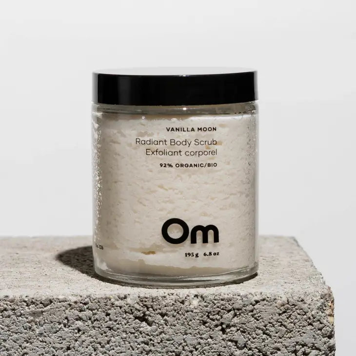A jar of body scrub with black lid showing the white alt scrub in the jar by Om Organics.