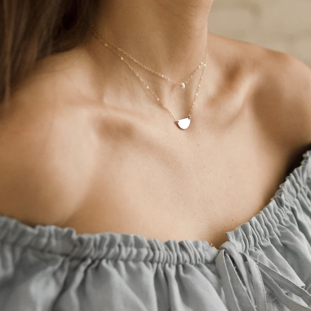 A gold-filled necklace jewelled with a mini pearl.