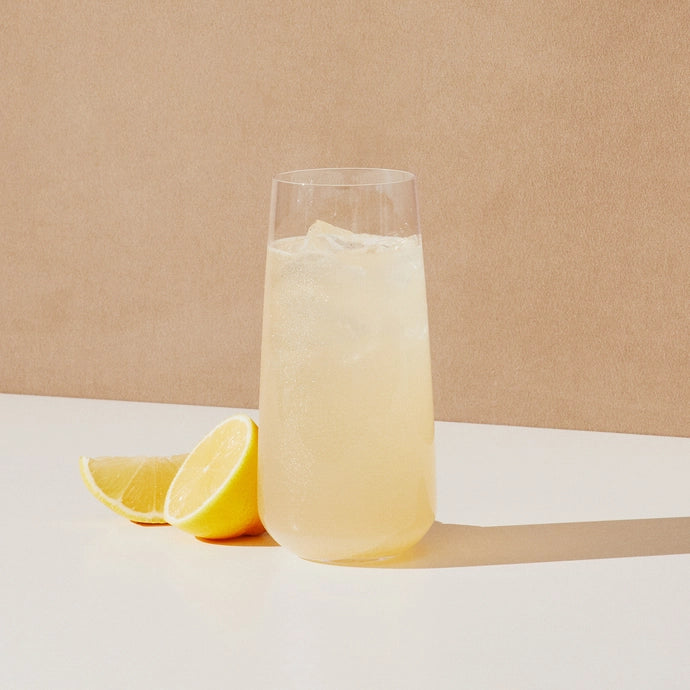 A glass of hydrating electrolyte drink mix in lemonade flavour from Cure Hydration.