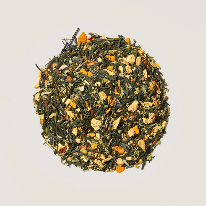 A pile of loose tea leaves of lemon, ginger and turmeric organic green tea.