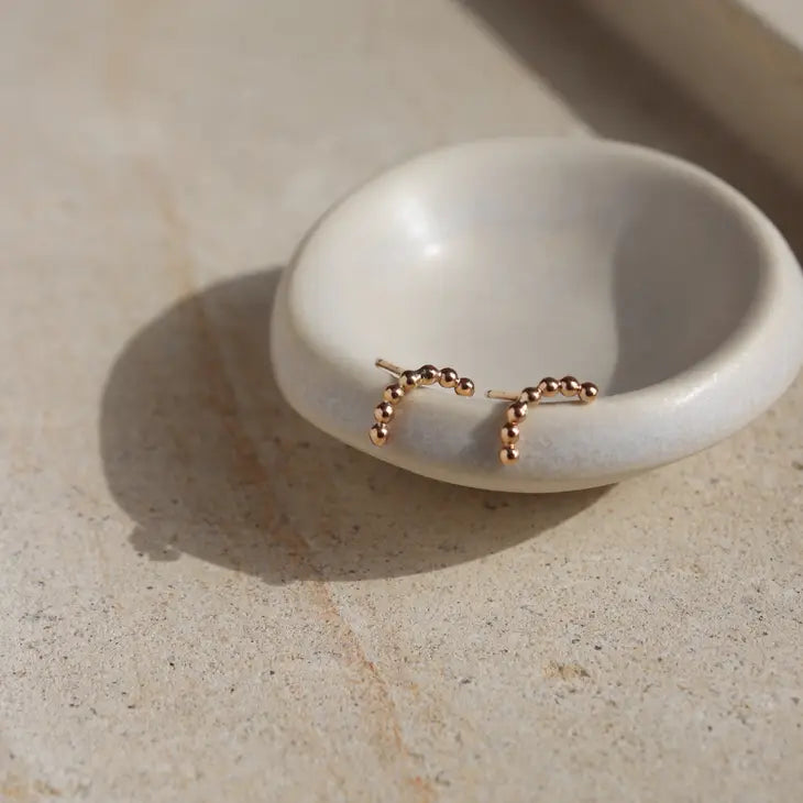 An arched stud earring in 14k yellow gold fill, by Token Jewelry.
