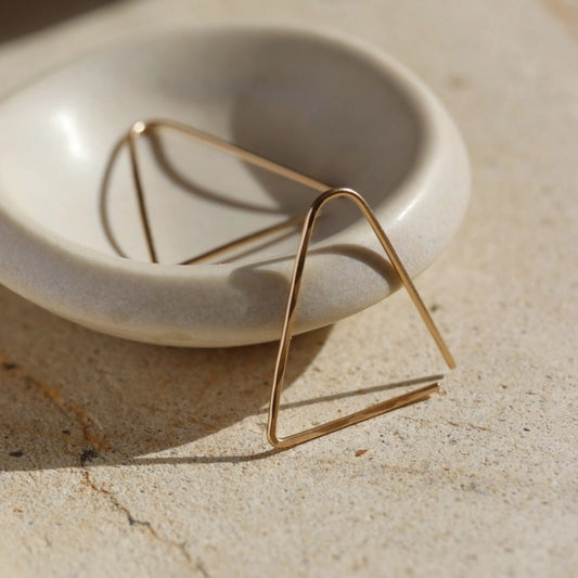 Triangle shaped earrings in 14k yellow gold fill that threads through the ear piercing, by Token Jewelry.